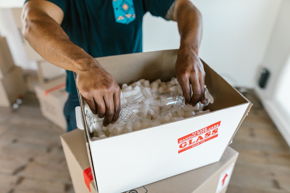 Movers carefully packing cardboard boxes