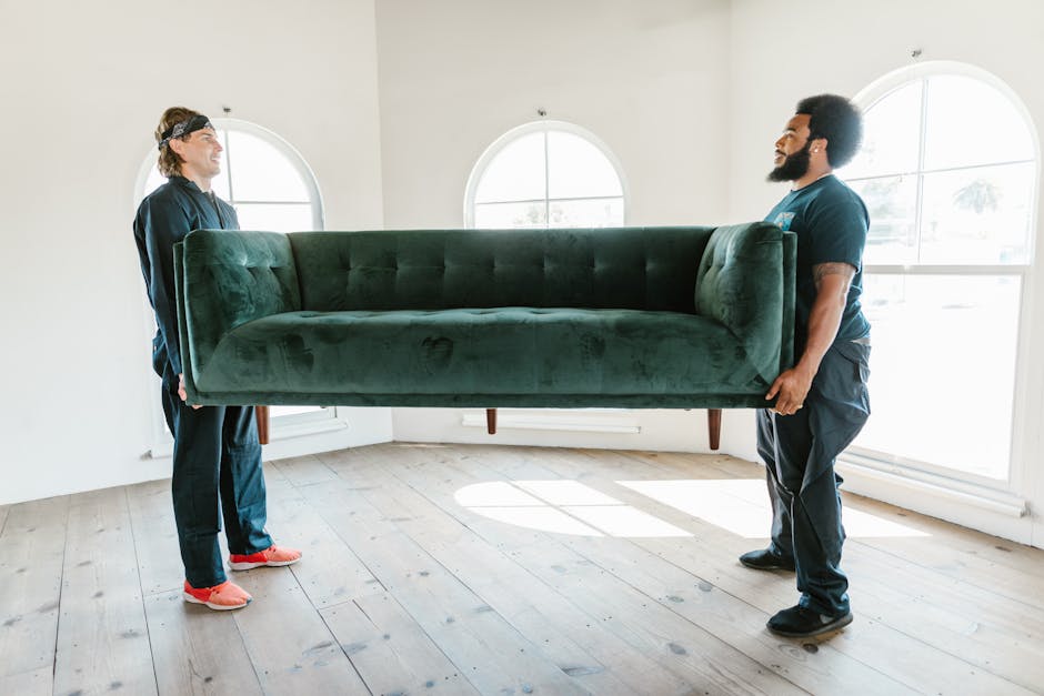 Movers carrying a heavy couch out of a home